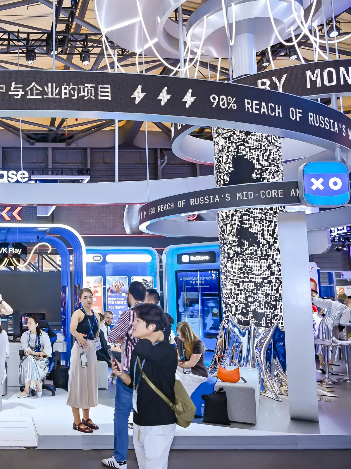 The LED birch on VK’s stand at ChinaJoy: a trunk of white LED dots under rings of running tickers, visitors around it